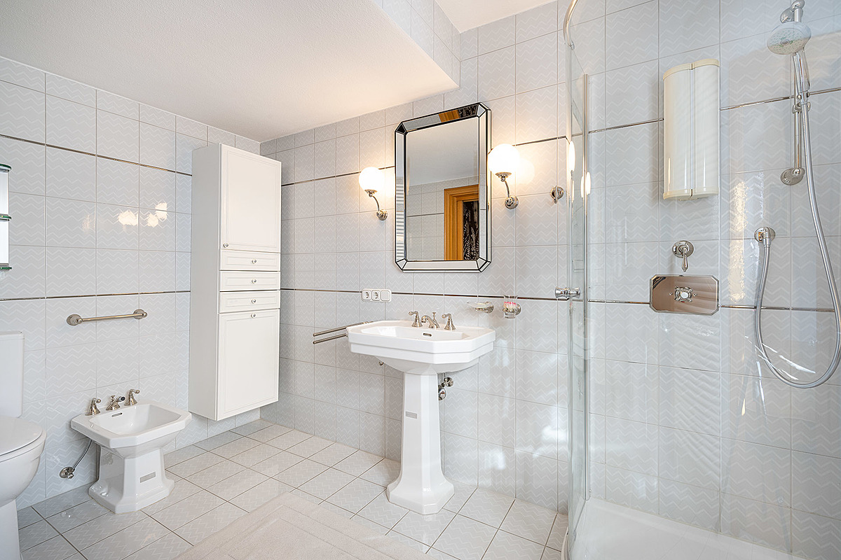Gepflegtes Mehrgenerationenhaus mit viel Potenzial - Badezimmer weiß gefliest mit Eckbadewanne