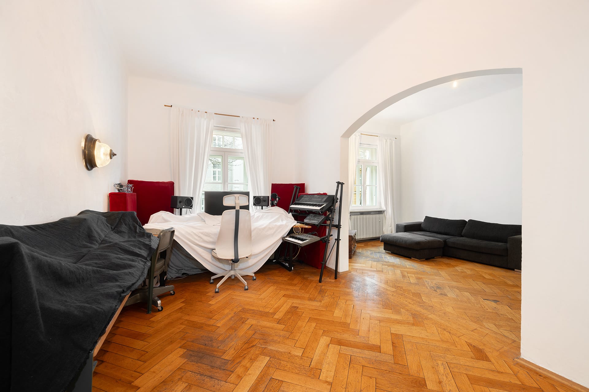 Außergewöhnliche, denkmalgeschützte 3-Zimmer-Stadtwohnung in München-Schwabing - Wohnzimmer mit Segmentbogen